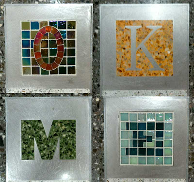 Closeups of the letters O K M and E in varying colors and materials