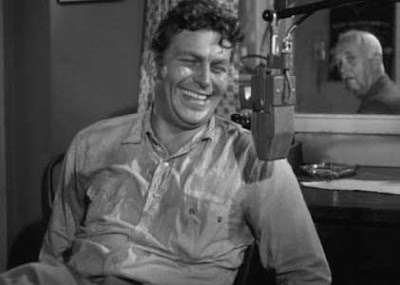 Andy Griffith as Lonesome Rhodes in front of a microphone