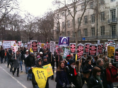 People with placards marching through a London street