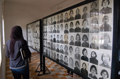 woman looking at wall of photographs of many individuals