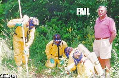 photo of a hazmat team in full gear and a guy in shorts watching them