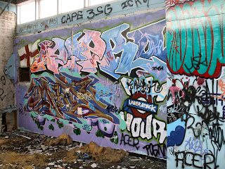 A graffiti covered wall in an abandoned factory
