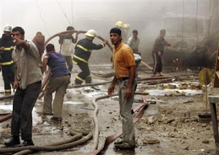 Residents and firemen gather at the scene of a car bomb attack in Baghdad, April 18, 2007. (REUTERS/Ali Jasim)