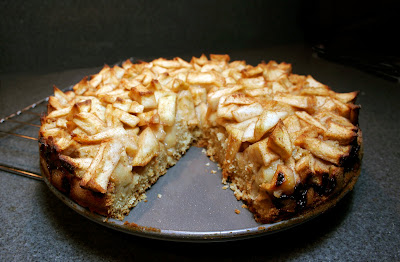 cake topped with chopped apples, with a wedge cut out