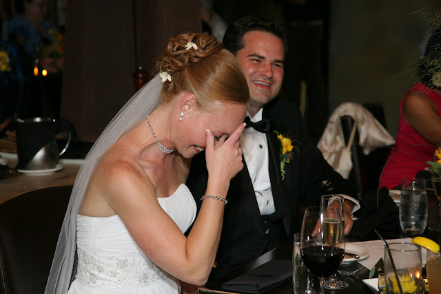 Bride covering face with hand from laughing at toast during Hinterland Erie Street Gastropub wedding reception