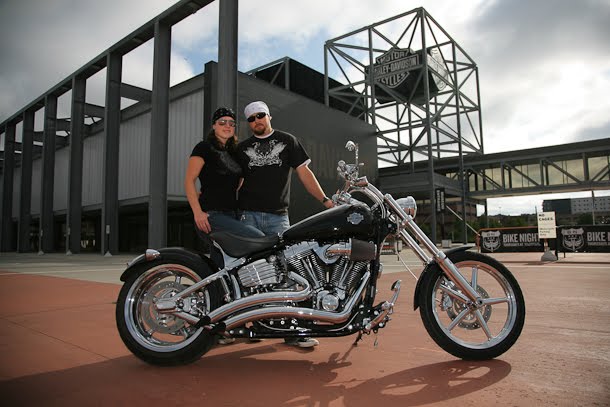 Engagement portrait with couple and motorcycle in front of Harley-Davidson museum