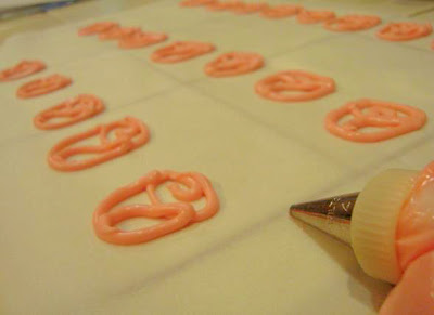 Pink candy melt made into rose outline shapes from a piping bag