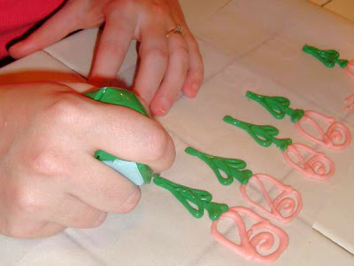 Green candy melt in piping bag being poured out to make rose stems