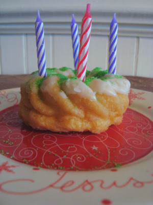Cruller doughnut with purple and pink candles
