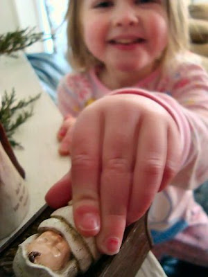 Tucking Baby Jesus Figurine in Manger