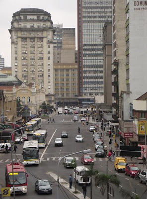 foto da Avenida Júlio de Castilhos em Porto Alegre, apresentando o Mercado Público à esquerda e o edifício da Prefeitura Nova ao fundo à esquerda