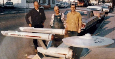 From the blog of Trek production illustrator John Eaves - Richard Datin takes delivery of the 11-foot version of the Enterprise in December of 1964 as its modelers, Mel Keys and Vern Sion, look on.