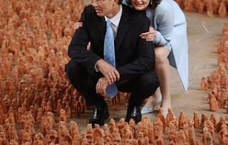 Tony Blair and his wife kneeling.