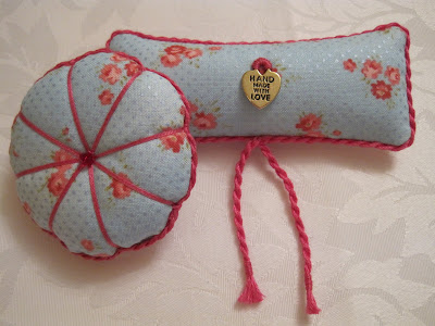 Round and oblong embroidered pin cushion, pale blue fabric and pretty pink flowers