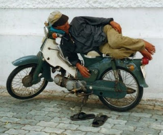 funny photo of man sleeping on his motorbike crazy