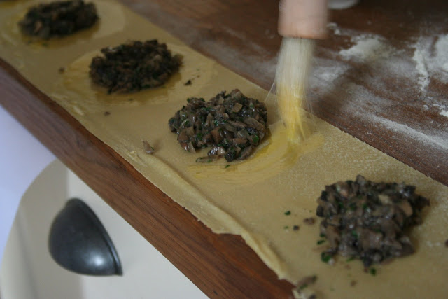 production line of ravioli, sealing the parcels with egg