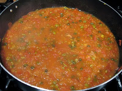 A close up photo of the tomato mixture in a large saute pan.