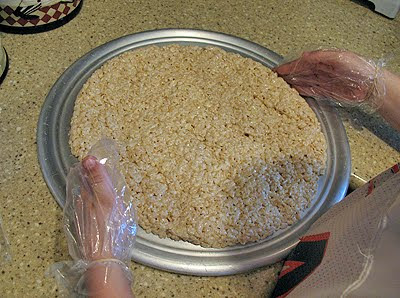 A photo of rice krispy treats shaped into a circle on a pizza pan.