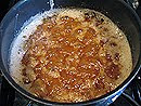 A photo of the caramel glaze boiling in a medium saucepan.