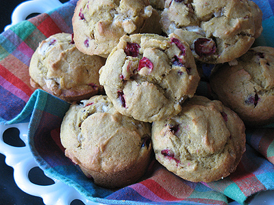 Pumpkin cranberry muffins with white chocolate chunks resting in a bowl.