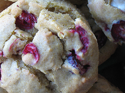 A close up photo of a pumpkin cranberry muffin with white chocolate chunks.
